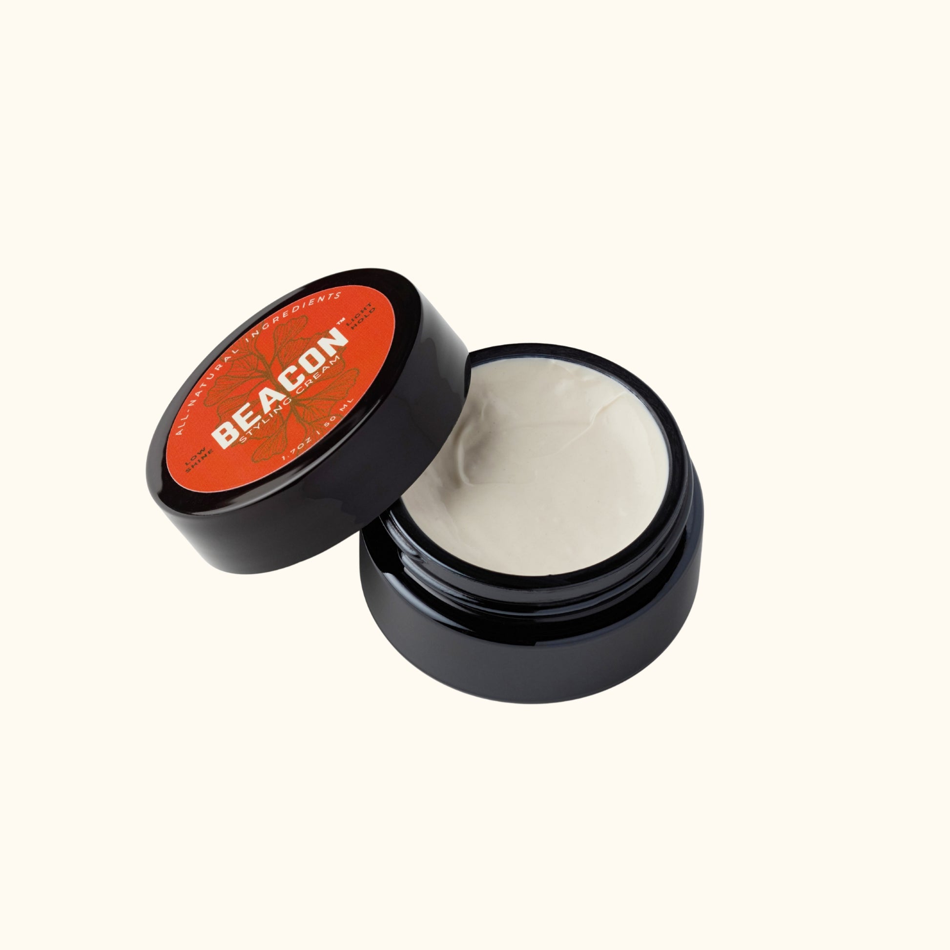 Open glossy black jar of Beacon Styling Cream showing smooth light hold hair cream, natural water-based formula for flexible styling.